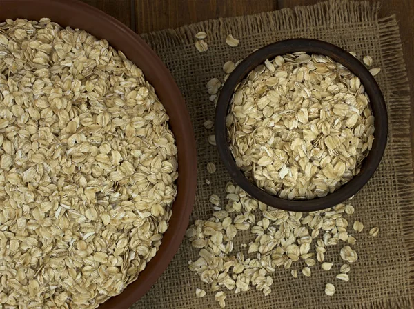 Harina de avena copos de avena seca en cuencos en el fondo —  Fotos de Stock