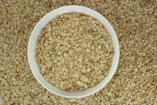 Dry oat flakes oatmeal in bowl on the background — Stock Photo, Image