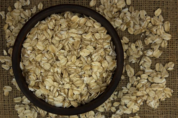 Seco copos de avena harina de avena en tazón en el saqueo —  Fotos de Stock