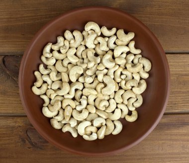 Kase dokulu ahşap arka plan, tablo üstten görünüm üzerinde ham kaju fıstığı