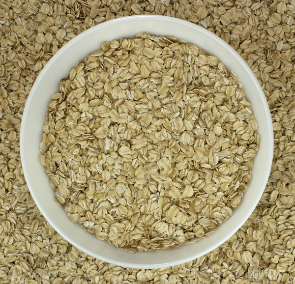 Dry oat flakes oatmeal in  bowl on the background — Stock Photo, Image