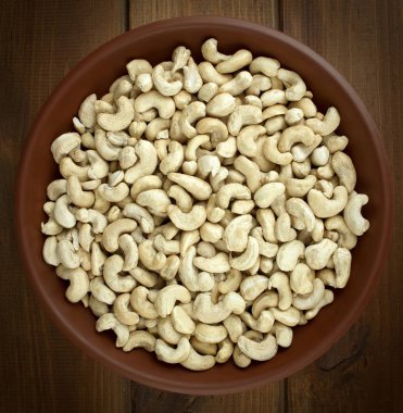 Kase desenli ahşap arka plan üzerinde ham kaju fıstığı