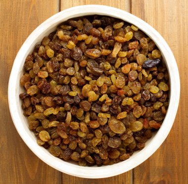 Ahşap arka plan üzerinde kase kuru üzüm