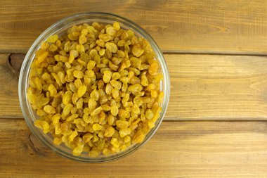 Ahşap arka plan üzerinde kase kuru üzüm