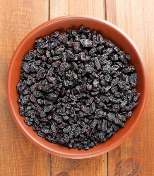 Ahşap arka plan üzerinde kase kuru üzüm