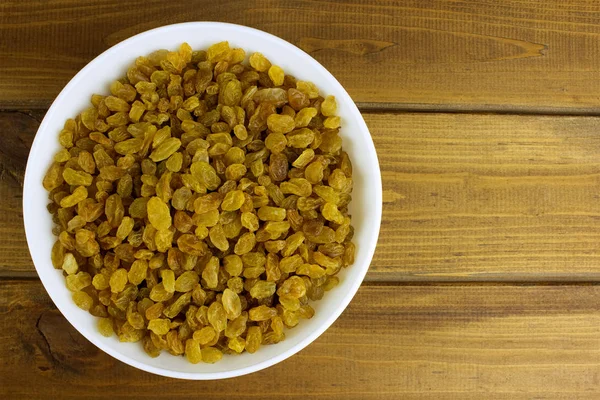 Ahşap arka plan üzerinde kase kuru üzüm