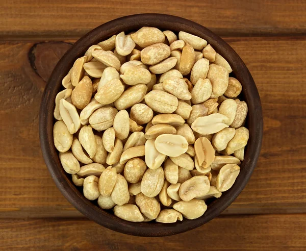 Kase bir ahşap zemin üzerine kavrulmuş tuzlu fıstık