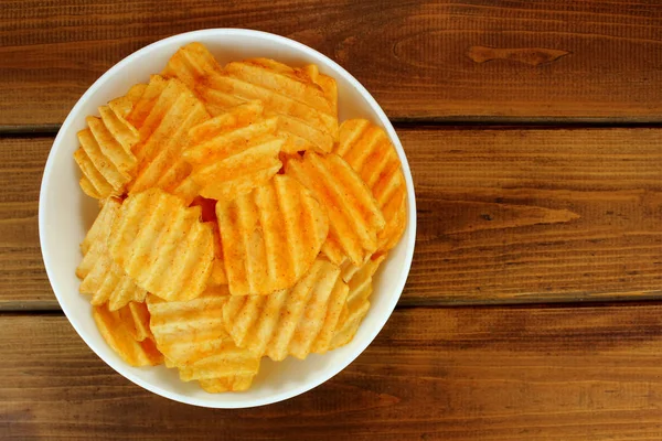 Patatas fritas en un tazón sobre un fondo de madera, vista superior — Foto de Stock