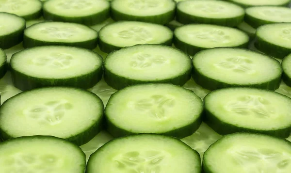 Verse komkommer plakjes achtergrond. — Stockfoto