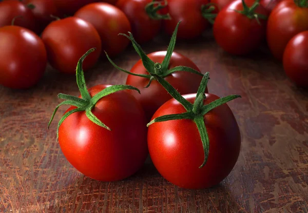 Tomates em fundo de madeira, iluminação escura — Fotografia de Stock