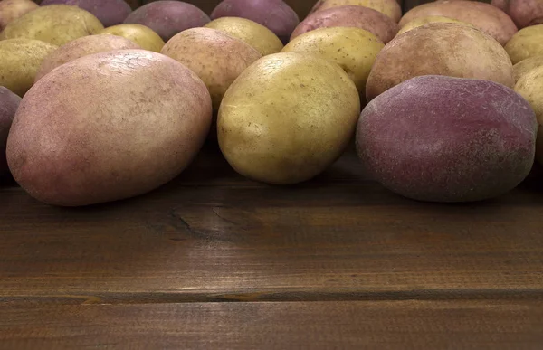 Potatoes on wood background — Stock Photo, Image