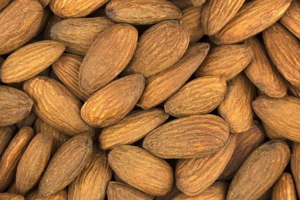 Background of scattered almond nuts closeup