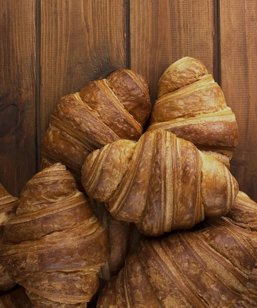 Gustosi croissant su fondo di legno — Foto Stock