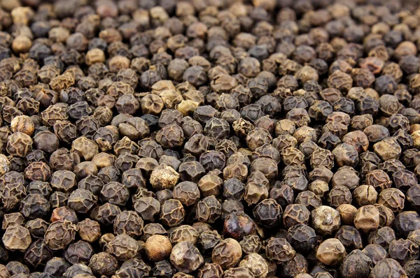 Black peppercorn seeds background. Macro shot Stock Picture