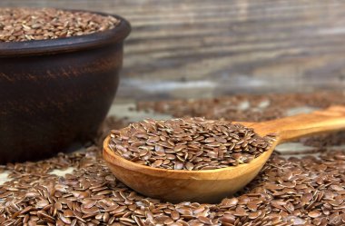 Kase üzerinde ahşap dağınık tahıllar ile keten tohumu wi arka plan