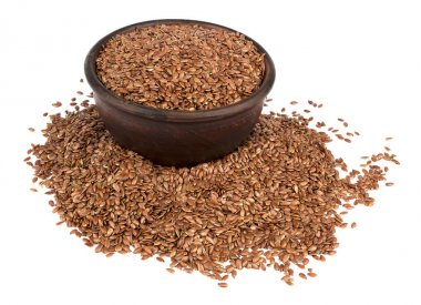 Seramik kase beyaz arka plan üzerinde izole keten tohumu.