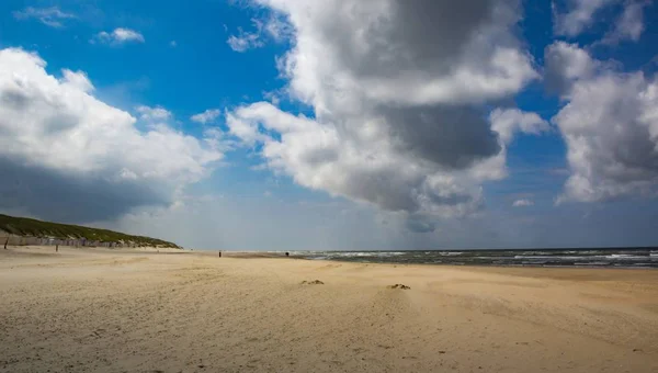 Nederlandse strand op een heldere dag met enkele wolken — Stockfoto