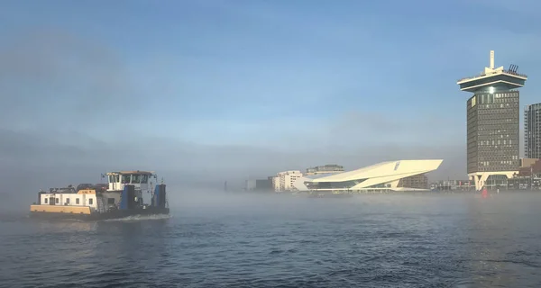 Човен в туман в Амстердамі гавані Стокове Зображення