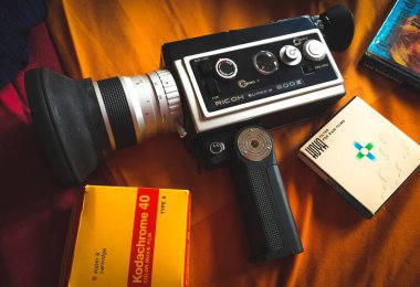 Bir battaniyenin renkli arkaplan bantlı retro 8mm film kamerası