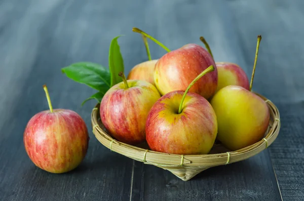 Červené a žluté jablko na dřevěné pozadí — Stock fotografie