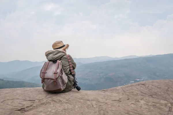 Hipster fille assis dans rocheux de montagne Image En Vente