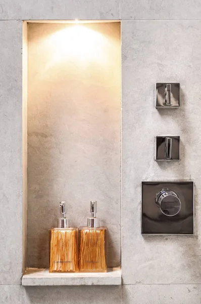 Ham beton duvar ile tasarlanmış banyo şişe raf ve krom Duş Vana ile dekore edilmiştir.