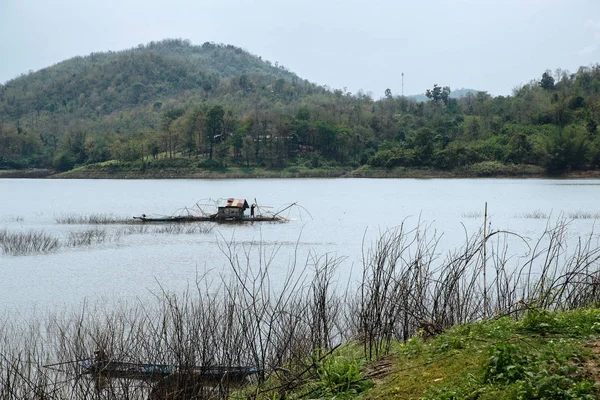 Bir balıkçı tekne evinde Samorthong rezervuar Uthaithani Tayland çalışır.