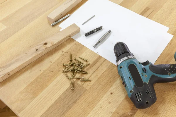 Screws and an electric screwdriver — Stock Photo, Image