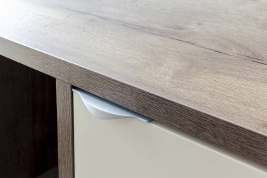 Ahşap bir komodin üzerindeki metal kolu