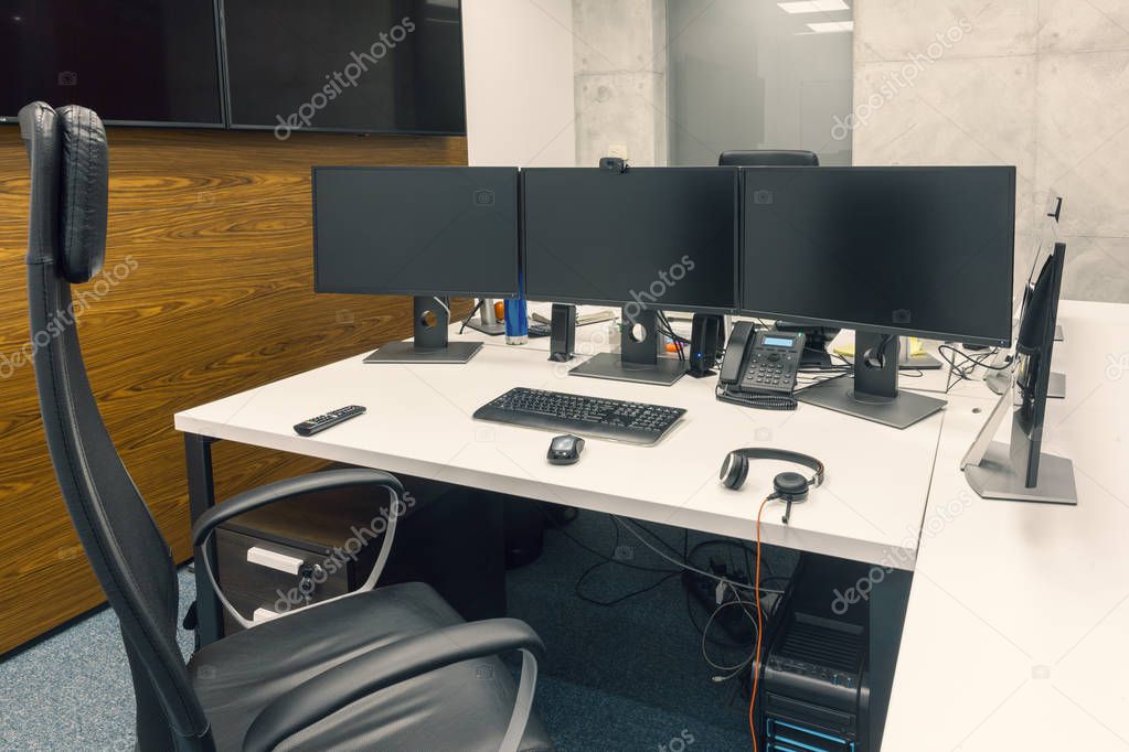 desktop with three monitors in office