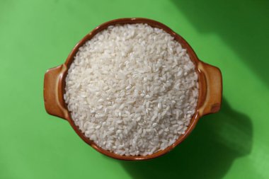 Seramik kasede beyaz pirinç, yeşil arka plan