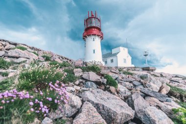 Dünya ünlü Lindesnes Fyr feneri Güney noktası Norveç'in kenarında kayalık deniz sahil üzerinde üzerinde dramatik gökyüzü