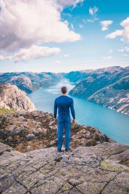 Norveç, dikiz dağlarda güzel rock kenarında duran genç adam