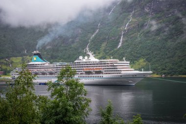 Geiranger, Norveç - Ağustos 2016: Ms Geiranger yağışlı ve sisli gün yelken Artania.