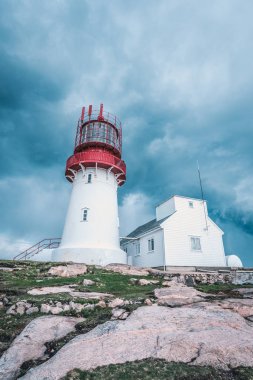 Dünya ünlü Lindesnes Fyr feneri Güney noktası Norveç'in kenarında kayalık deniz sahil üzerinde üzerinde dramatik gökyüzü