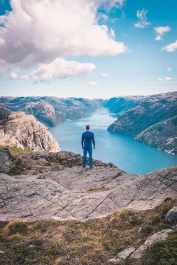 Norveç, dikiz dağlarda güzel rock kenarında duran genç adam