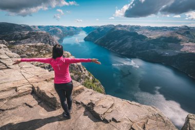 Norveç'in dağlarında güzel rock kenarında duran genç kadın.