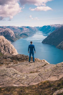 Norveç, dikiz dağlarda güzel rock kenarında duran genç adam