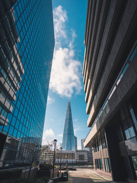 LONDON, UK - MARCH, 2016: The Shard is the tallest skyscraper in London standing along River Thames, with a height of 309.6 meters. Low angle view from a narrow street