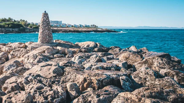 Small stone lighthouse staying on cape near sea in Cyprus