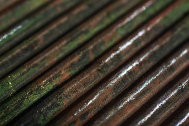 Kahverengi ve yeşil arkaplanı bulanık olan dikey dışbükey çizgileri olan eğimli köşegen dokusu