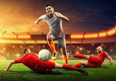 Futbolcular top için savaşıyor. Profesyonel şampiyonluk. Dramatik gökyüzü olan gece futbol stadyumu
