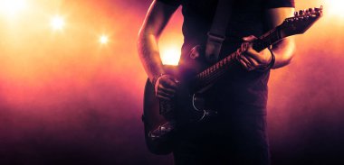 Man playing the guitar in spotlight. Musical performance clipart