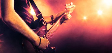 Sahnede çalan bir gitaristin elleri. Görüntüyü kapat