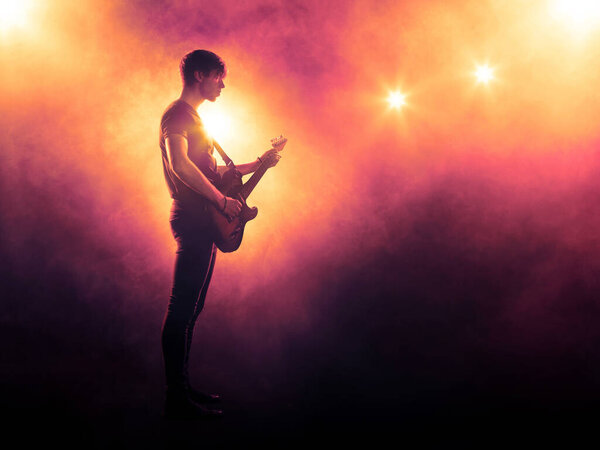 Guitar player silhouette on stage in spotlight