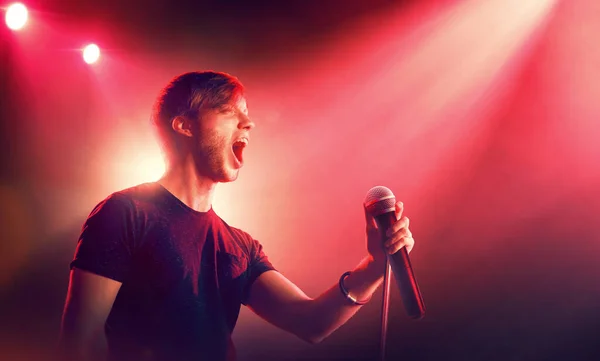 Singer with microphone in spotlight. Music performance