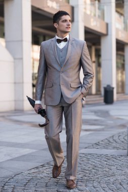 Şemsiye ile gri elbiseli adam