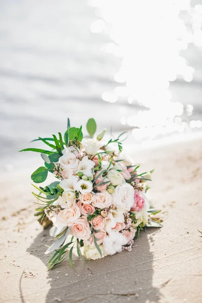 Bouquet flowers laying on beach