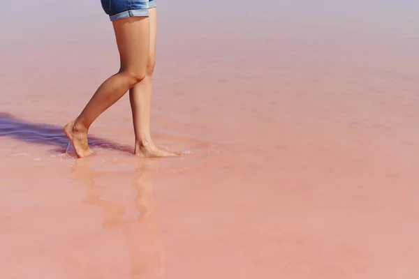 Femmes jambes marchant sur le lac salé rose Images De Stock Libres De Droits