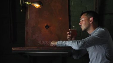 Karanlık bir barda bekleyen yalnız adam yerleştirin ve bira içmek